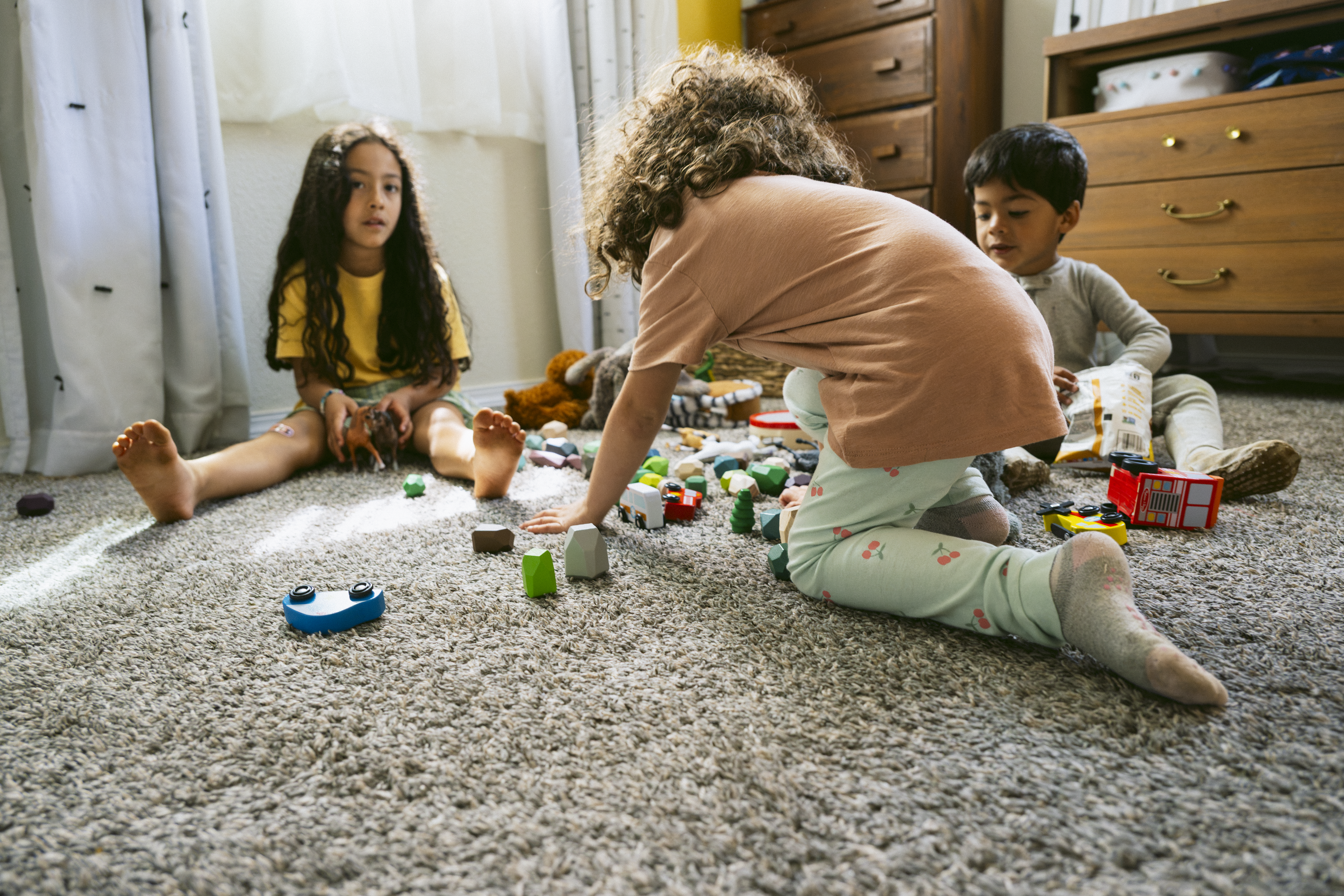 Children playing on the floor in their bedroom.
